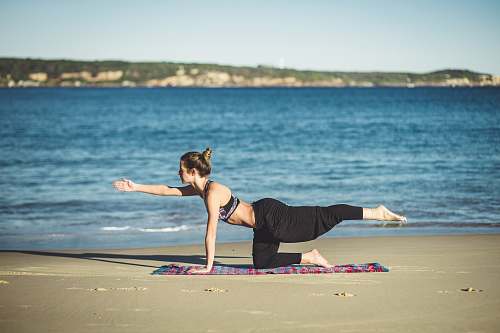 sport woman doing yoga on seashore fitness